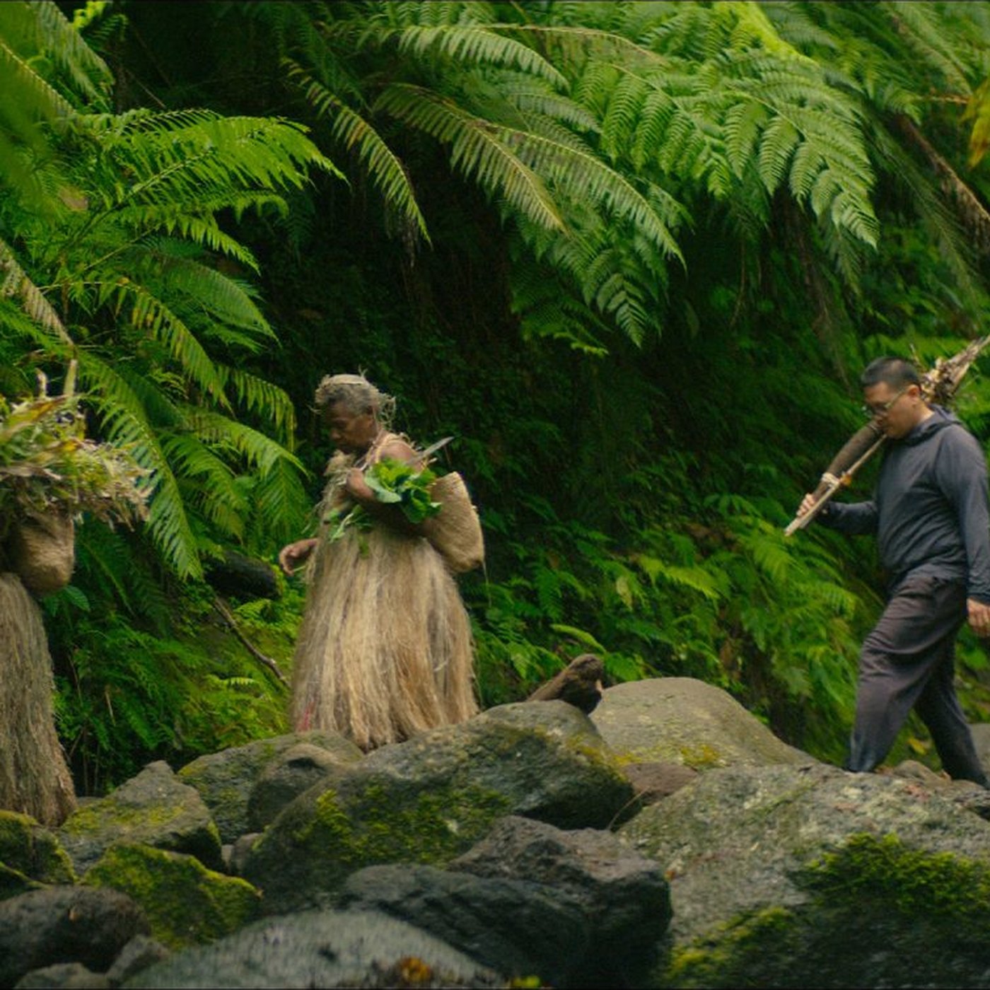 An elder and Julian Aguon walking through ferns