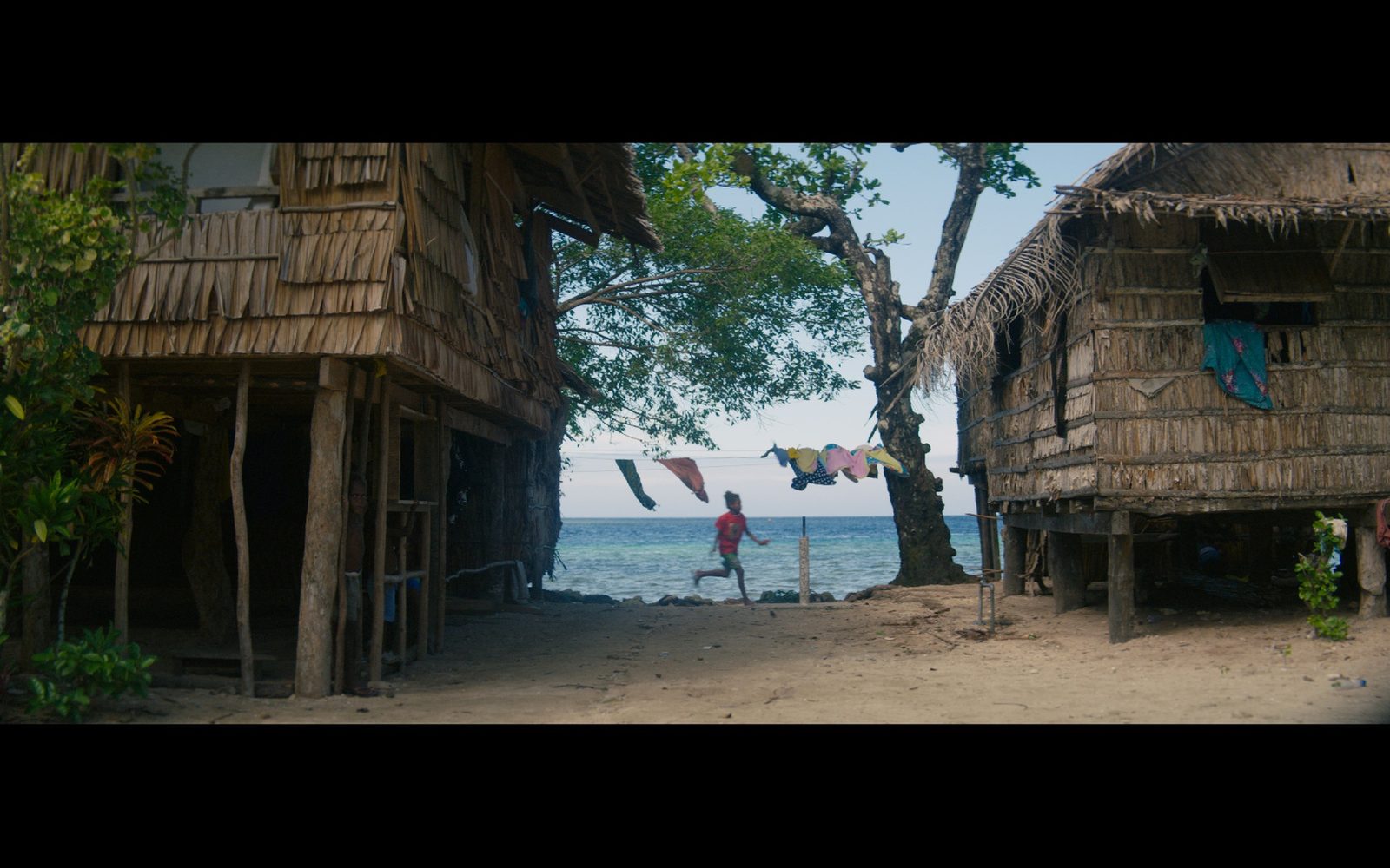 A child running past a house on the shore