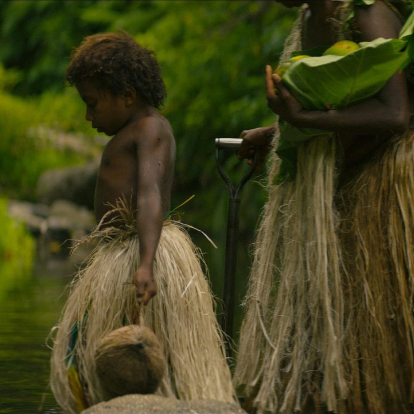 Women and a child of Yakel standing in a stream